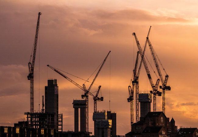 Construction cranes at sunset